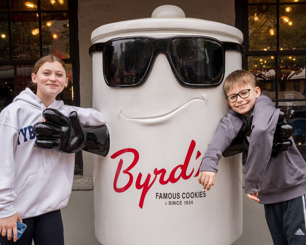 A girl and a boy posing with the Cookie Jar at Byrd's Famous Cookies